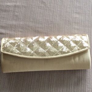 Gold clutch bag with a chain shoulder strap.